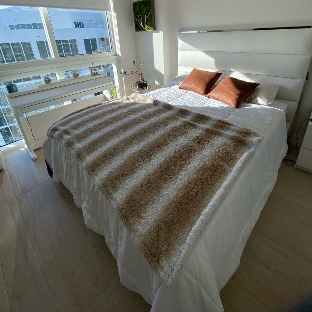 Decorative faux leather pillows with stripped throw blanket